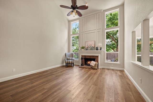 3312 John Ct N, Hurst, TX 76054 - living area with high vaulted ceiling, wood finished floors, plenty of natural light, a ceiling fan, and a fireplace