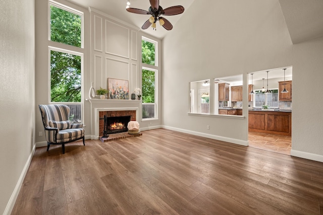 3312 John Ct N, Hurst, TX 76054 - living room with a towering ceiling, healthy amount of natural light, ceiling fan, wood finished floors, and a fireplace