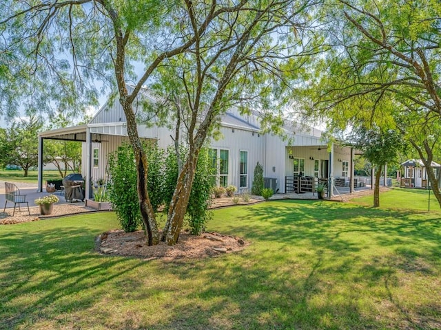 245 Vickie Ln, Gunter, TX 75058 - back of property featuring a patio area, a lawn, and board and batten siding