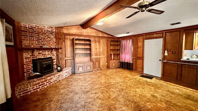 801 High St, Newcastle, TX 76372 - unfurnished living room featuring a textured ceiling, carpet flooring, built in shelves, wood walls, and ceiling fan