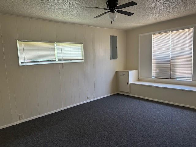 6832 Craig St, Fort Worth, TX 76112 - spare room with ceiling fan, a textured ceiling, electric panel, and dark colored carpet