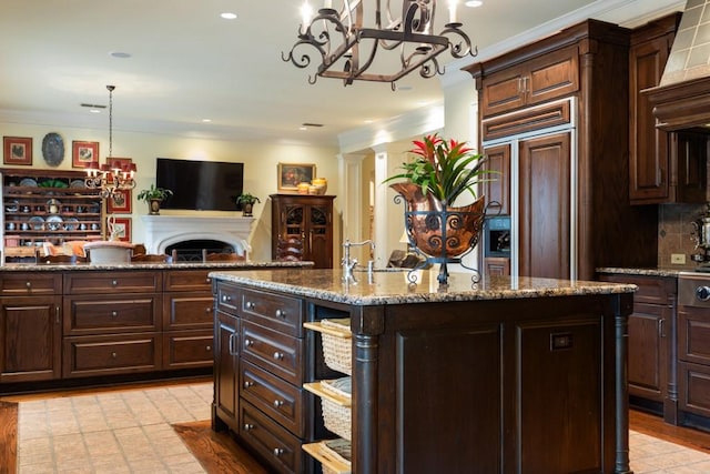 3048 Concord Pl, Tyler, TX 75701 - kitchen featuring a chandelier, paneled fridge, ornamental molding, open floor plan, and a fireplace