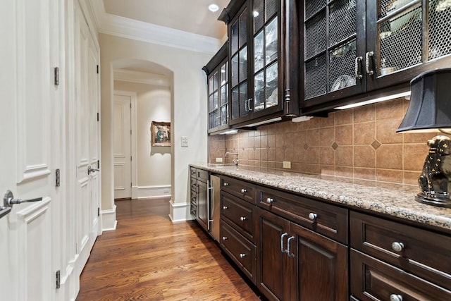 3048 Concord Pl, Tyler, TX 75701 - bar area featuring arched walkways, crown molding, backsplash, and dark wood finished floors