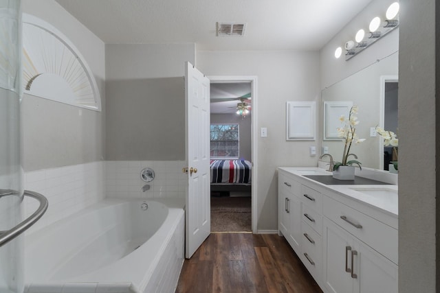 2625 Hudson Xing, Mckinney, TX 75072 - full bathroom with wood finished floors, a ceiling fan, double vanity, a bath, and ensuite bathroom