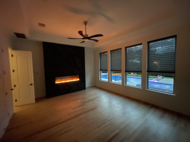 320 W Highland St, Southlake, TX 76092 - empty room featuring wood finished floors, a lit fireplace, and a ceiling fan