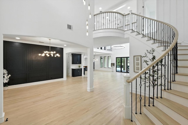 320 W Highland St, Southlake, TX 76092 - foyer with a chandelier, wood finished floors, a towering ceiling, stairway, and arched walkways