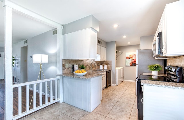 6005 Frontier Ln, Plano, TX 75023 - kitchen featuring appliances with stainless steel finishes, washer and clothes dryer, tasteful backsplash, white cabinets, and light tile patterned flooring