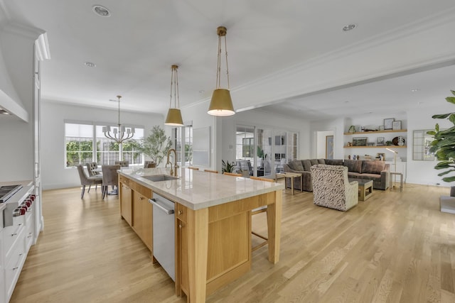 6819 Park Ln, Dallas, TX 75225 - kitchen featuring stainless steel appliances, light wood-style flooring, a kitchen island with sink, a breakfast bar area, and a chandelier