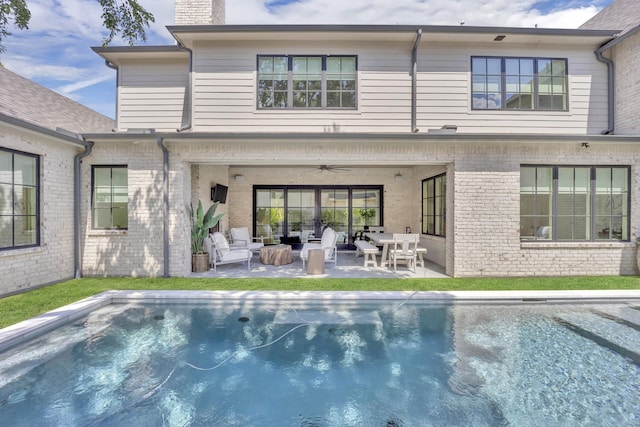 6819 Park Ln, Dallas, TX 75225 - rear view of house with a ceiling fan, a chimney, brick siding, a patio area, and an outdoor pool