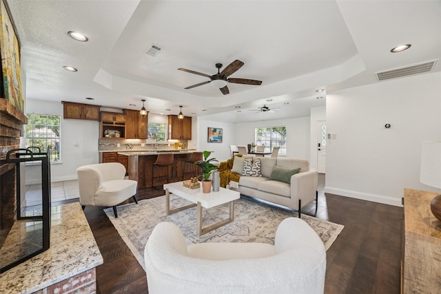 321 Malero Dr, Grand Prairie, TX 75051 - living area featuring a raised ceiling, ceiling fan, recessed lighting, plenty of natural light, and a fireplace