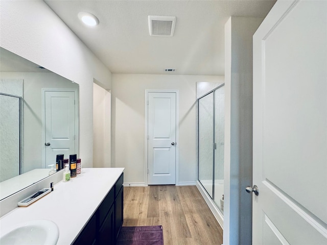 2808 Jasmine Dr, Sherman, TX 75092 - bathroom featuring wood finished floors, a stall shower, and vanity