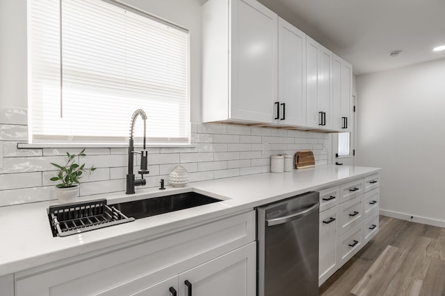 1105 Trellis Dr, Garland, TX 75040 - kitchen with stainless steel dishwasher, backsplash, and white cabinetry