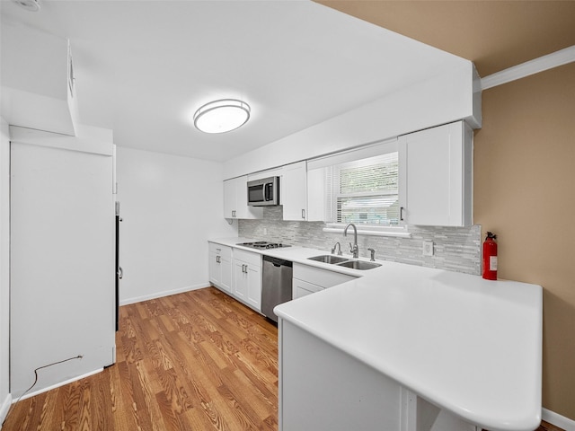 903 20th St, Plano, TX 75074 - kitchen featuring stainless steel appliances, decorative backsplash, white cabinets, light wood-style floors, and light countertops