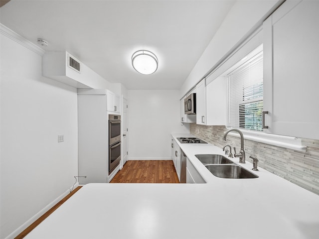 903 20th St, Plano, TX 75074 - kitchen with appliances with stainless steel finishes, tasteful backsplash, dark wood finished floors, and white cabinetry
