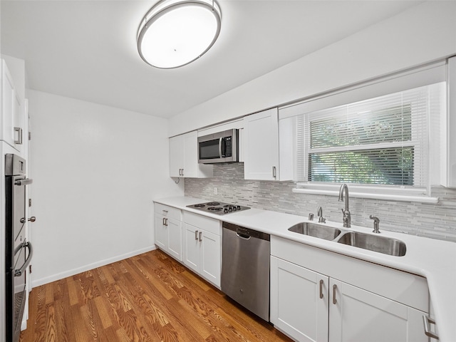 903 20th St, Plano, TX 75074 - kitchen featuring appliances with stainless steel finishes, decorative backsplash, white cabinetry, light countertops, and light wood-type flooring