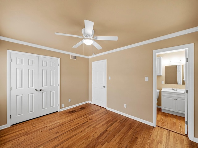 903 20th St, Plano, TX 75074 - unfurnished bedroom featuring crown molding, light wood finished floors, a closet, connected bathroom, and ceiling fan
