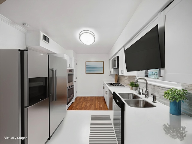 903 20th St, Plano, TX 75074 - kitchen with appliances with stainless steel finishes, white cabinetry, decorative backsplash, wood finished floors, and light countertops