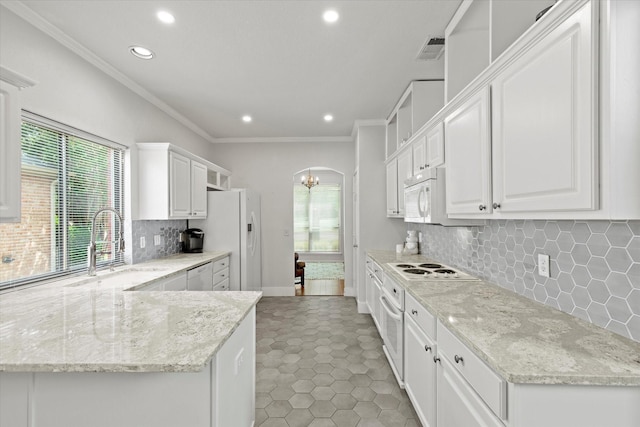 6749 Misty Hollow Dr, Plano, TX 75024 - kitchen featuring recessed lighting, white appliances, white cabinets, plenty of natural light, and ornamental molding