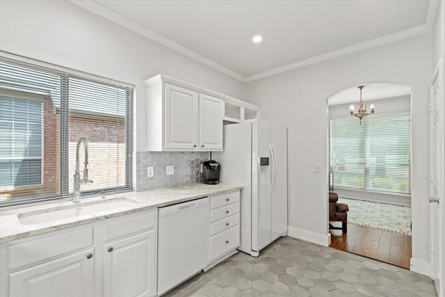 6749 Misty Hollow Dr, Plano, TX 75024 - kitchen with dishwasher, a chandelier, crown molding, arched walkways, and light tile patterned flooring