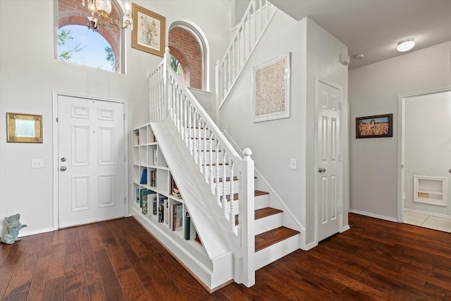 6749 Misty Hollow Dr, Plano, TX 75024 - stairway featuring hardwood / wood-style floors, a chandelier, and a towering ceiling