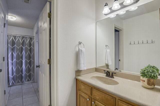 3008 Stone Bluff Ct, Arlington, TX 76017 - full bath featuring vanity, tile patterned flooring, and a shower with curtain