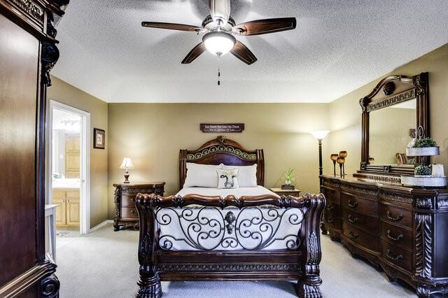 3008 Stone Bluff Ct, Arlington, TX 76017 - bedroom featuring light colored carpet, a textured ceiling, ceiling fan, and ensuite bath