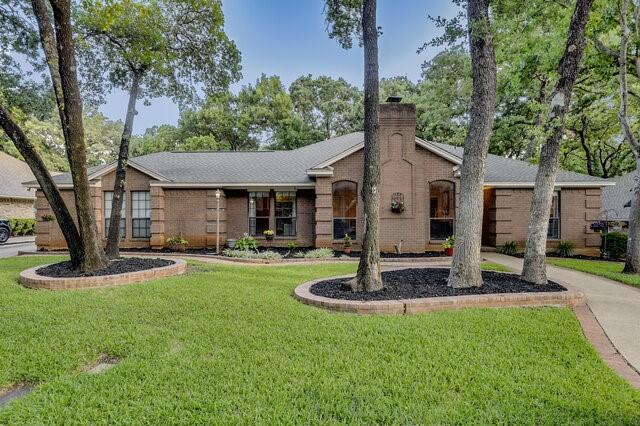 3008 Stone Bluff Ct, Arlington, TX 76017 - view of front facade with a front yard, brick siding, and a chimney