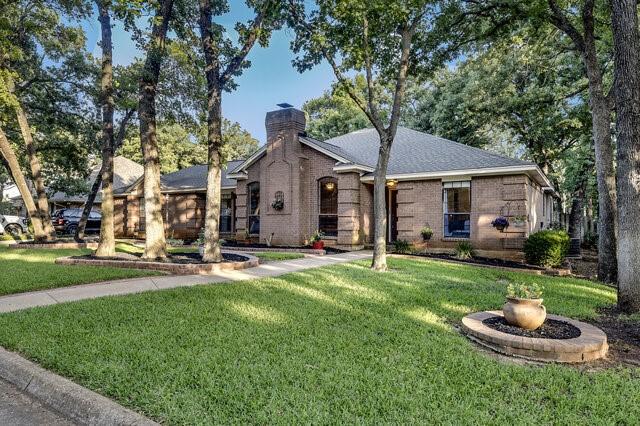 3008 Stone Bluff Ct, Arlington, TX 76017 - view of front of home with a chimney, a front yard, and brick siding