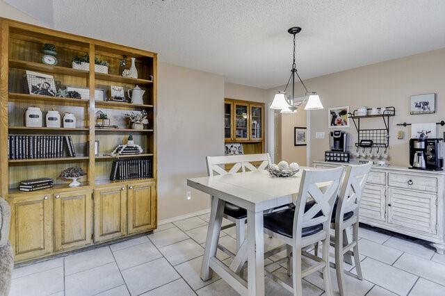 3008 Stone Bluff Ct, Arlington, TX 76017 - dining space with light tile patterned floors and a textured ceiling