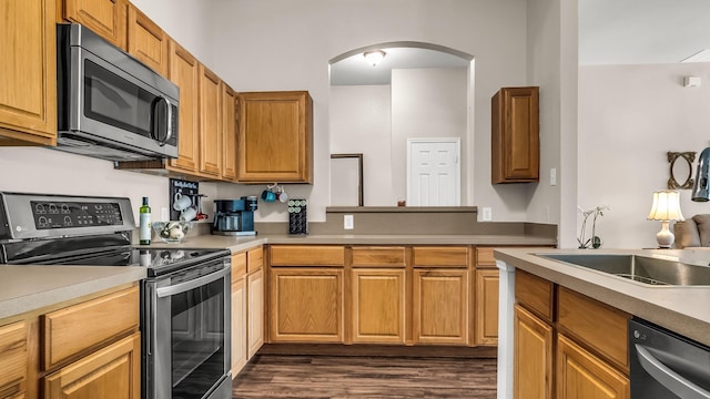 801 Lake Forest Trl, Little Elm, TX 75068 - kitchen with appliances with stainless steel finishes, arched walkways, light countertops, and dark wood finished floors