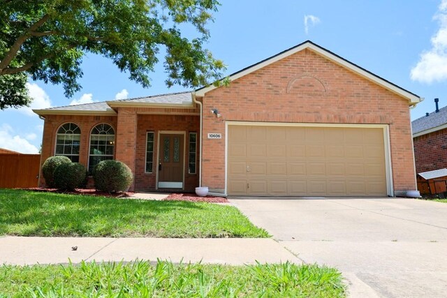 10606 Greenbriar Ln, Rowlett, TX 75089 - ranch-style home featuring an attached garage, brick siding, and driveway
