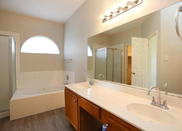 10606 Greenbriar Ln, Rowlett, TX 75089 - bathroom featuring wood finished floors, a stall shower, a bath, and double vanity
