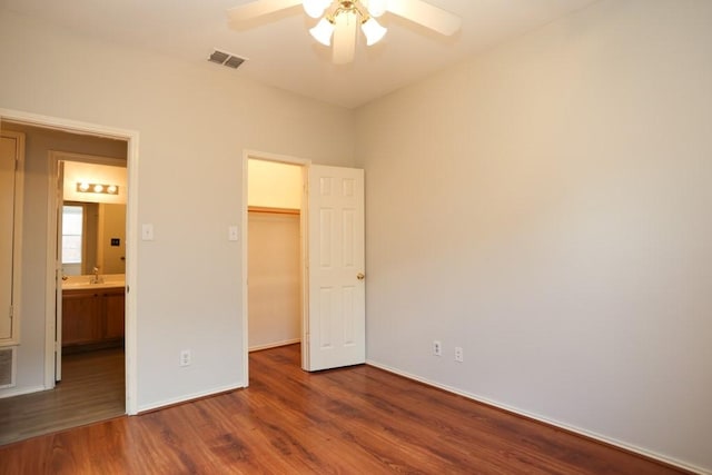 10606 Greenbriar Ln, Rowlett, TX 75089 - unfurnished bedroom with wood finished floors, a spacious closet, a closet, and a ceiling fan