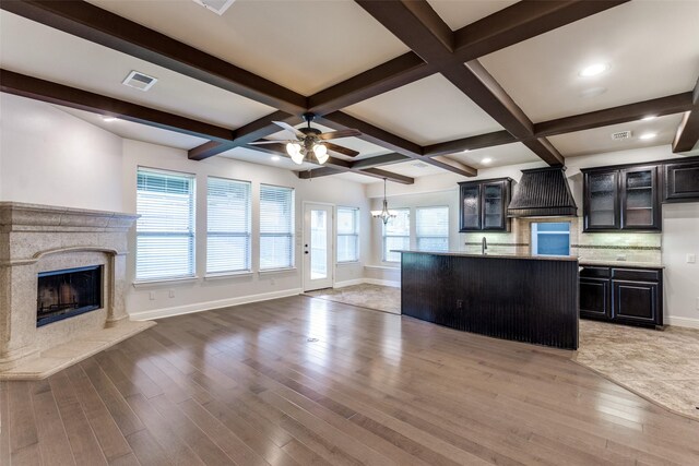905 Brendan Dr, Little Elm, TX 75068 - kitchen with custom exhaust hood, open floor plan, light wood-type flooring, a fireplace, and beamed ceiling