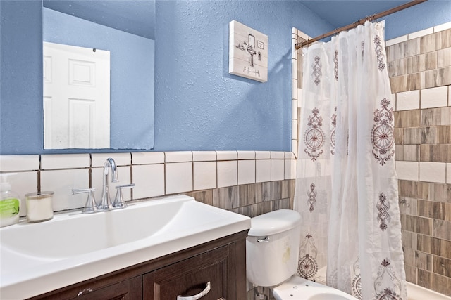 1106 Melrose St, Garland, TX 75040 - bathroom featuring a textured wall, tile walls, shower / bath combo with shower curtain, and vanity