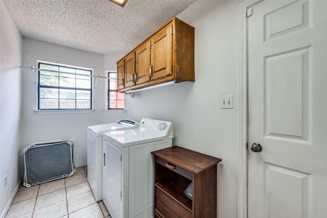 234 Raintree Dr, Highland Village, TX 75077 - laundry room featuring independent washer and dryer, cabinet space, light tile patterned flooring, and a textured ceiling
