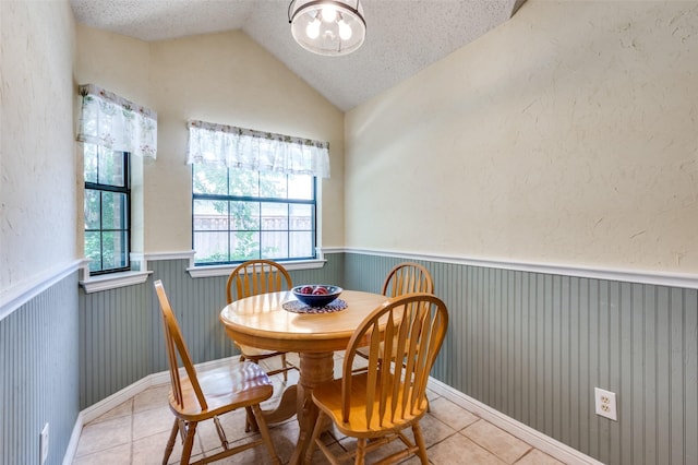 234 Raintree Dr, Highland Village, TX 75077 - dining area featuring tile patterned floors, a wainscoted wall, vaulted ceiling, a chandelier, and a textured ceiling