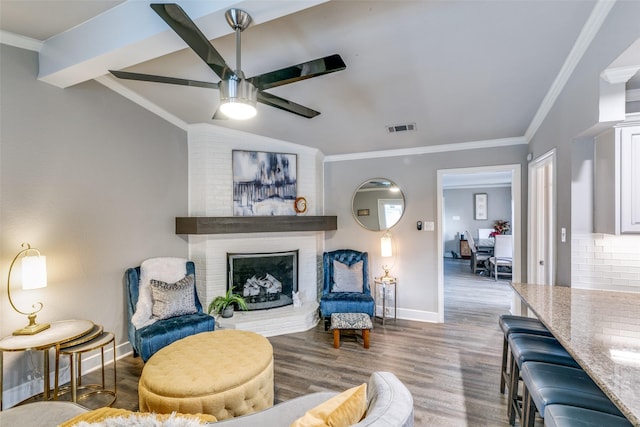 205 N Weatherred Dr, Richardson, TX 75080 - living area with wood finished floors, a ceiling fan, a brick fireplace, crown molding, and vaulted ceiling
