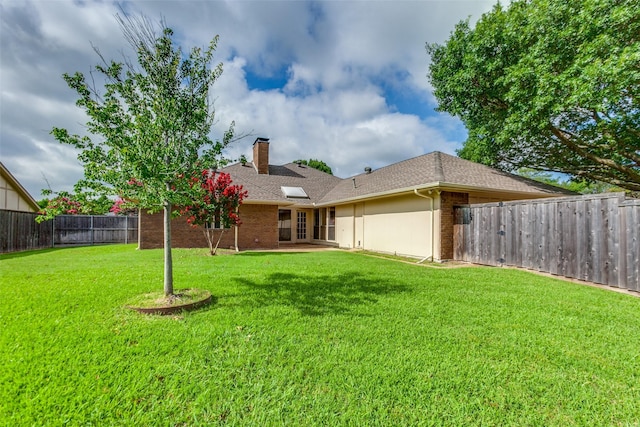 2307 Silver Holly Ln, Richardson, TX 75082 - rear view of house with a chimney, brick siding, a fenced backyard, and roof with shingles