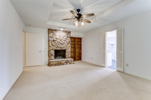 2307 Silver Holly Ln, Richardson, TX 75082 - unfurnished living room with a raised ceiling, a stone fireplace, a ceiling fan, and carpet flooring