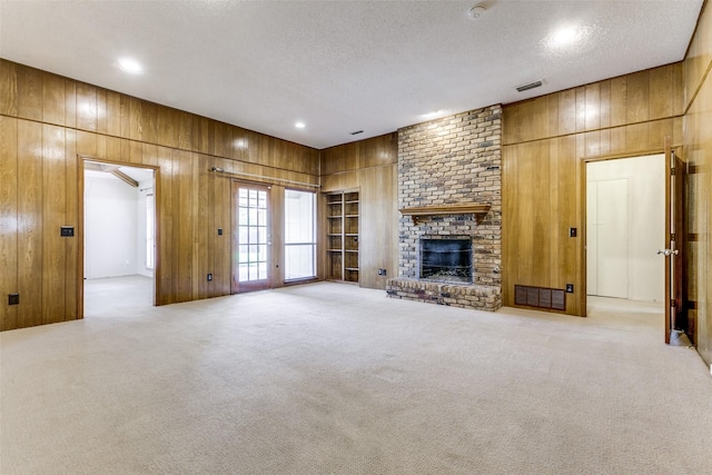 2307 Silver Holly Ln, Richardson, TX 75082 - unfurnished living room featuring wood walls, a textured ceiling, carpet floors, a fireplace, and recessed lighting