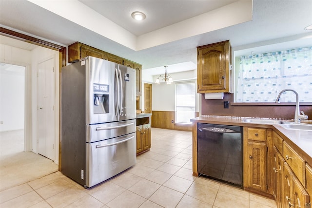 2307 Silver Holly Ln, Richardson, TX 75082 - kitchen featuring stainless steel refrigerator with ice dispenser, dishwasher, brown cabinets, a wainscoted wall, and a chandelier