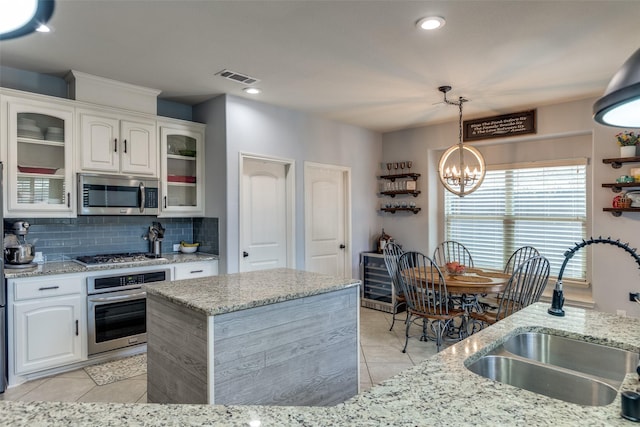 824 Mist Flower Dr, Little Elm, TX 75068 - kitchen featuring appliances with stainless steel finishes, a chandelier, light tile patterned floors, backsplash, and recessed lighting
