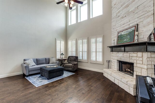 824 Mist Flower Dr, Little Elm, TX 75068 - living room with ceiling fan, dark wood finished floors, a stone fireplace, and a high ceiling