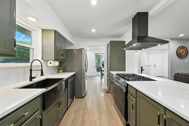 336 Davis Dr, Desoto, TX 75115 - kitchen featuring wall chimney range hood, appliances with stainless steel finishes, green cabinetry, light wood-type flooring, and recessed lighting