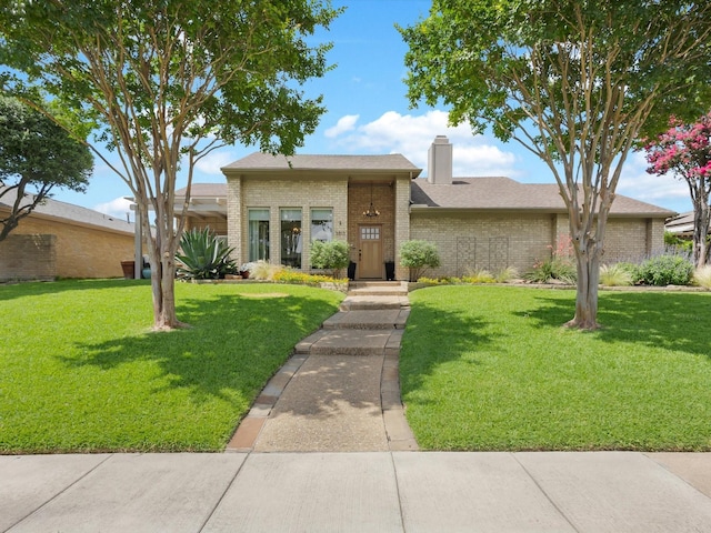 3813 Fall Wheat Dr, Plano, TX 75075 - view of front of home with brick siding, a chimney, a front lawn, and roof with shingles