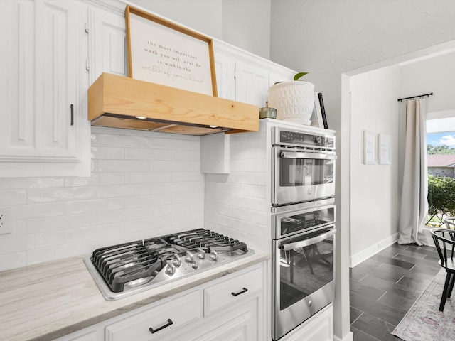 3813 Fall Wheat Dr, Plano, TX 75075 - kitchen with stainless steel appliances, decorative backsplash, white cabinetry, premium range hood, and light stone counters