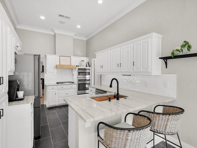 3813 Fall Wheat Dr, Plano, TX 75075 - kitchen featuring a peninsula, stainless steel appliances, ornamental molding, decorative backsplash, and white cabinets