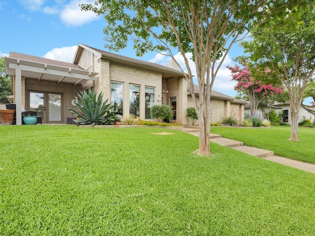 3813 Fall Wheat Dr, Plano, TX 75075 - view of front of house featuring brick siding, a front lawn, french doors, and board and batten siding
