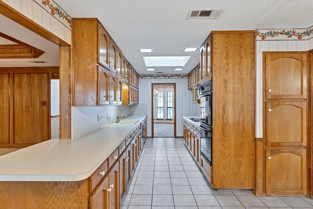 7254 Hialeah Cir W, North Richland Hills, TX 76182 - kitchen with brown cabinetry, a textured ceiling, light countertops, light tile patterned floors, and white fridge